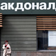 woman on smartphone outside russian mcdonald's